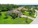 Beautiful home showcasing a well-manicured lawn, lush landscaping, and a brick driveway leading to a three-car garage at 15608 31St E St, Parrish, FL 34219