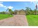 Inviting single-story home featuring a brick driveway, a two-car garage, and meticulously manicured landscaping at 15608 31St E St, Parrish, FL 34219
