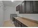 Laundry room offers dark cabinets, granite countertops, stainless steel appliances, and a utility sink at 15608 31St E St, Parrish, FL 34219
