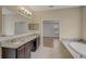 Luxurious main bathroom with a large soaking tub, separate shower, dual sinks, tile surround, and granite counters at 15608 31St E St, Parrish, FL 34219