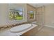 Sunlight streams into this main bathroom featuring a soaking tub and a glass enclosed shower at 15608 31St E St, Parrish, FL 34219