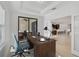 Bright home office with a large wooden desk, patio access, and an open view to the modern kitchen at 15608 31St E St, Parrish, FL 34219