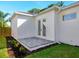 A white stucco exterior shows a back patio and double doors with brick flooring and a small window at 2246 Webber St, Sarasota, FL 34239
