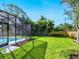 Wide shot of the screened-in pool and lush backyard with privacy fence at 2246 Webber St, Sarasota, FL 34239