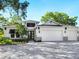 Front exterior with manicured landscaping, stone accents, and a three-car garage is warm and inviting at 2246 Webber St, Sarasota, FL 34239
