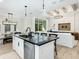 Spacious kitchen island with black countertop, white cabinets, and barstool seating overlooking a living space at 2246 Webber St, Sarasota, FL 34239