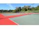 Outdoor tennis courts with green and red surfaces, surrounded by fencing and trees at 2246 Webber St, Sarasota, FL 34239