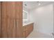 Bathroom boasting wood cabinets with white countertops, an integrated sink, and a recessed, illuminated mirror at 2590 Floyd St, Sarasota, FL 34239