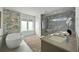 Modern bathroom featuring a soaking tub, spacious shower, and sleek marble walls at 2590 Floyd St, Sarasota, FL 34239