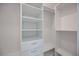 Bright, walk-in closet featuring white organizers, shelving, closet rods, and drawers at 2590 Floyd St, Sarasota, FL 34239