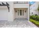 Inviting entrance with a glass-paneled door, sconces, and tiled walkway at 2590 Floyd St, Sarasota, FL 34239