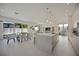 Bright, open-concept kitchen with dining area, large island, modern lighting, and access to outdoor living space at 2590 Floyd St, Sarasota, FL 34239