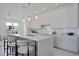 This bright kitchen features a large center island, bar stool seating, modern cabinetry and fixtures at 2590 Floyd St, Sarasota, FL 34239