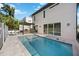 Backyard oasis featuring a swimming pool with built-in grill, modern pergola, and sleek white exterior at 2590 Floyd St, Sarasota, FL 34239