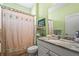 Bathroom featuring marble countertops, decorative shower curtain, and ample storage on shelving unit at 27243 Ipswich Dr, Englewood, FL 34223