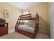 Bedroom showcasing a wooden bunk bed frame, a dresser with decorations, and a window with natural light at 27243 Ipswich Dr, Englewood, FL 34223