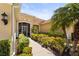 Inviting front entrance featuring a screened porch, tiled walkway, and colorful, manicured landscaping at 27243 Ipswich Dr, Englewood, FL 34223