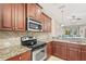 Well-equipped kitchen with stainless steel appliances, granite countertops, and wood cabinets for culinary enthusiasts at 27243 Ipswich Dr, Englewood, FL 34223