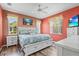 Stylish bedroom with coral walls, white furnishings, and abundant natural light from two windows at 27243 Ipswich Dr, Englewood, FL 34223