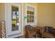 Cozy patio area with wicker chairs, a small table, and a 'beach' sign near the door at 27243 Ipswich Dr, Englewood, FL 34223