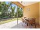 Enclosed patio with stone flooring, wicker furniture, and a view of the green backyard at 27243 Ipswich Dr, Englewood, FL 34223