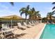 Community pool showcasing a tile deck with lounge chairs and views of lush landscaping and blue skies at 27243 Ipswich Dr, Englewood, FL 34223