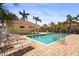 Community pool surrounded by tile deck, lush landscaping, lounge chairs, and a pool house at 27243 Ipswich Dr, Englewood, FL 34223
