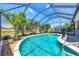 Captivating pool enclosed by a screen, boasting serene water, swaying palms, and charming exterior views at 2871 Phoenix Palm Ter, North Port, FL 34288
