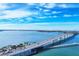Picturesque aerial view of a bridge over the water, with a road, palm trees, and a pier nearby at 300 S Pineapple Ave # 302, Sarasota, FL 34236