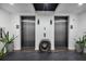 Elevator lobby with a modern wood block accent piece, tile floors, and planters at 300 S Pineapple Ave # 302, Sarasota, FL 34236
