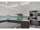 Bright kitchen featuring white cabinets, stainless appliances, and a light blue tiled backsplash at 300 S Pineapple Ave # 302, Sarasota, FL 34236
