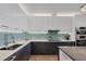 Modern kitchen featuring sleek white cabinets, stainless steel appliances, and a stylish tile backsplash at 300 S Pineapple Ave # 302, Sarasota, FL 34236