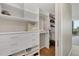 Spacious walk-in closet features custom shelving, drawers, and hardwood floors at 300 S Pineapple Ave # 302, Sarasota, FL 34236
