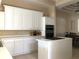 Kitchen featuring white cabinetry, stainless steel double ovens, and center island at 3405 54Th W Dr # 104, Bradenton, FL 34210