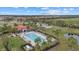 Aerial view of a community pool, clubhouse, and a nearby pond and recreation areas at 3415 Big Sky Way, Bradenton, FL 34211