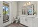 Bright bathroom with marble countertop, modern fixtures, and access to an outdoor patio with a grill at 3415 Big Sky Way, Bradenton, FL 34211