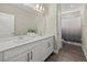 Modern bathroom featuring a double sink vanity with bronze hardware and a shower-tub combo with decorative curtain at 3415 Big Sky Way, Bradenton, FL 34211