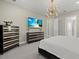 Bedroom with modern light fixture, black and gold furniture and a large wall mounted television at 3415 Big Sky Way, Bradenton, FL 34211