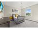 Cozy bedroom featuring a crib, complemented by a modern light fixture and ample natural light from a window at 3415 Big Sky Way, Bradenton, FL 34211