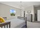 Bright bedroom with a window view, stylish light fixture, and a gray chest of drawers for ample storage at 3415 Big Sky Way, Bradenton, FL 34211