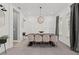 Elegant dining room featuring a modern light fixture and a long wooden table with seating for six at 3415 Big Sky Way, Bradenton, FL 34211