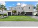 Elegant two-story home with a well-manicured lawn, three-car garage, and decorative architectural details at 3415 Big Sky Way, Bradenton, FL 34211