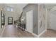 Grand foyer with soaring ceilings, elegant staircase, decorative wall accents, and wood-look tile flooring at 3415 Big Sky Way, Bradenton, FL 34211