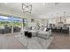 Open-concept living area with a gray sectional, modern lighting, and a seamless transition to the outdoor dining at 3415 Big Sky Way, Bradenton, FL 34211