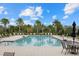 Community pool area with lounge chairs and lush landscaping at 3415 Big Sky Way, Bradenton, FL 34211