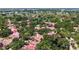 Aerial view of a home nestled among lush trees with a red tile roof in a serene neighborhood at 3605 Quail Hollow Ln, Bradenton, FL 34210