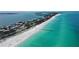 Aerial view of a coastal community with homes along a sandy beach and clear turquoise water on a sunny day at 3605 Quail Hollow Ln, Bradenton, FL 34210
