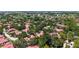 Aerial view showcases the lushly landscaped neighborhood featuring tile roofs and beautiful green spaces at 3605 Quail Hollow Ln, Bradenton, FL 34210