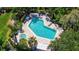 Aerial view of a community pool and spa surrounded by tropical landscaping at 3605 Quail Hollow Ln, Bradenton, FL 34210
