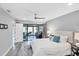 Light, airy bedroom features a queen bed, ceiling fan, wood-look flooring and glass doors at 3955 Glen Oaks Manor Dr, Sarasota, FL 34232